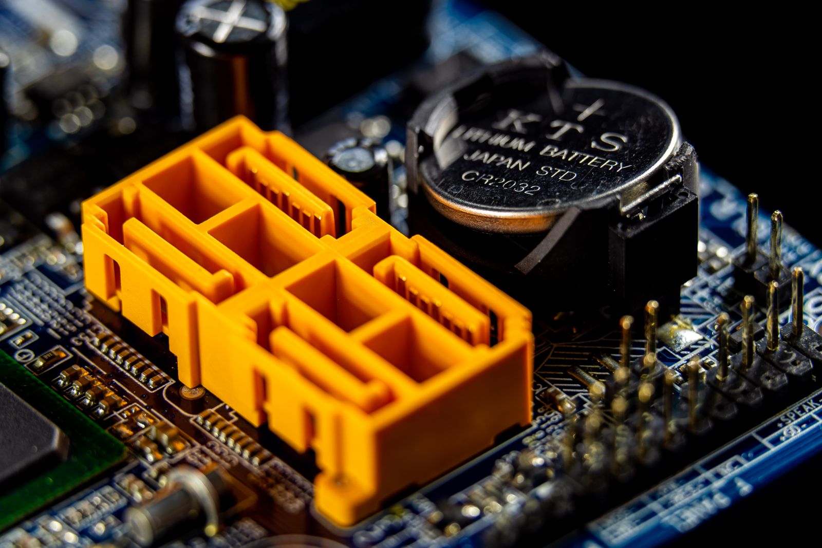 Close-up of a computer motherboard with an orange connector